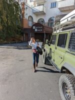 Woman approaching Landrover Defender in front of backdoor of Montauk Manor